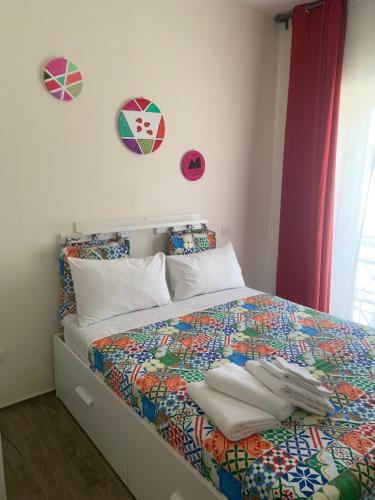 una camera da letto con un letto con un piumone colorato di Residenza La Ciorta a Napoli