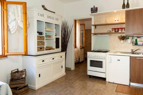 a kitchen with white cabinets and a stove at Relax a due passi dal mare in Piazza