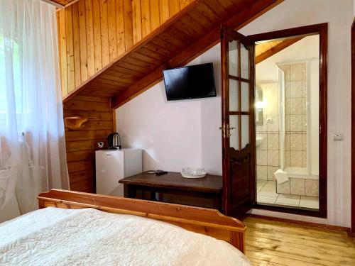 a bedroom with a bed and a tv on the wall at Satori in Migovo