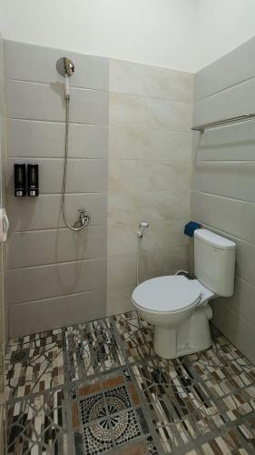 La salle de bains est pourvue d'une douche et de toilettes. dans l'établissement REG GUESTHOUSE, à Tanjungredep