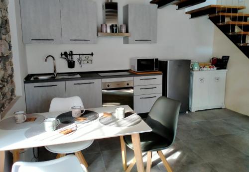 a kitchen with a table and chairs and a kitchen with a sink at Maison Cascina Amélie in Abbadia Lariana