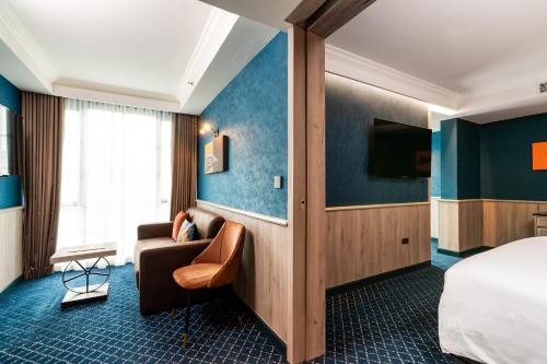 a hotel room with a couch and a bed at The Coach Hotel Sukhumvit - Asok BTS Bangkok in Bangkok