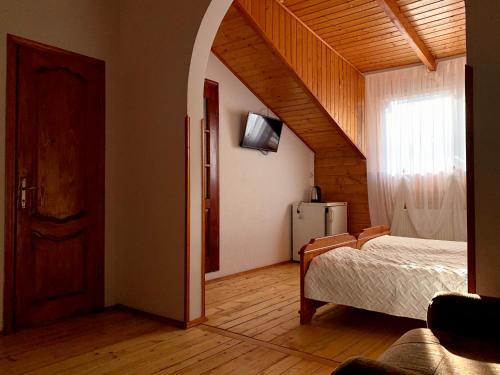 a bedroom with a bed and a staircase with a window at Satori in Migovo