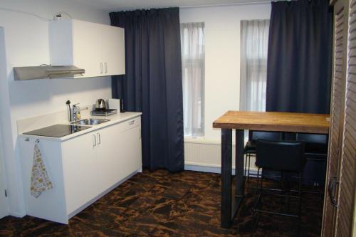 a small kitchen with a sink and a table at Hotel The Happy Traveler in Groningen
