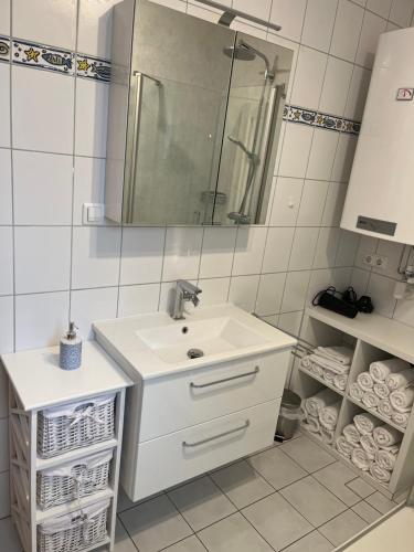 a white bathroom with a sink and a mirror at Casa al Lago in Faak am See
