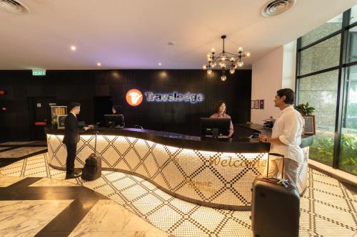 a group of people standing in a lobby with luggage at Travelodge Ipoh in Ipoh