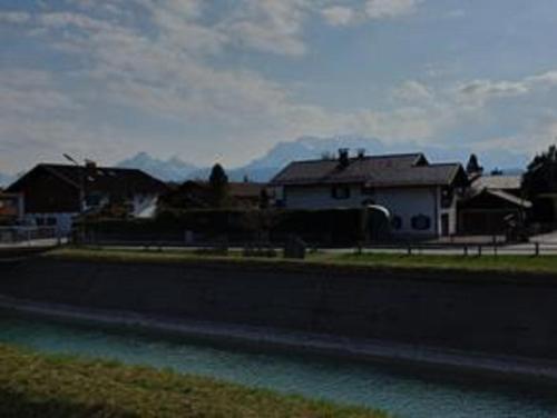 a house sitting next to a body of water at Ferienwohnung Rudis Bergblick in Wallgau
