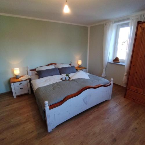 a bedroom with a large bed and two lamps on tables at Ferienwohnung Alter Kräuterhof in Mildenau