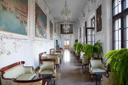 a hallway with chairs and paintings on the walls at Zamek w Baranowie Sandomierskim in Baranów Sandomierski