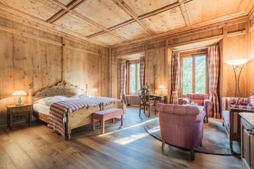 Schlafzimmer mit einem Bett, einem Tisch und Stühlen in der Unterkunft Parkhotel Margna Superior in Sils Maria