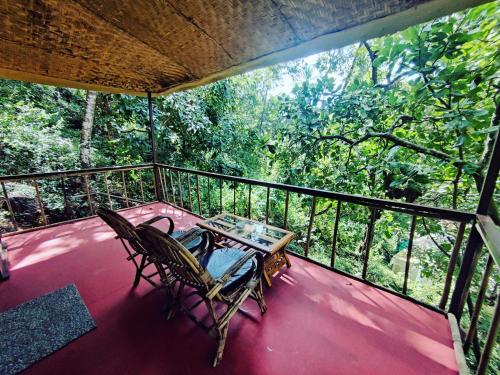 a porch with a table and chairs on a balcony at Samyama Retreat in Cola