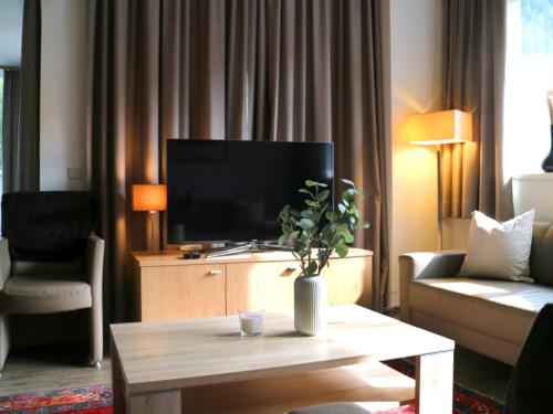 - un salon avec une télévision et une table basse dans l'établissement Chalet Lenzi, à Sankt Anton am Arlberg