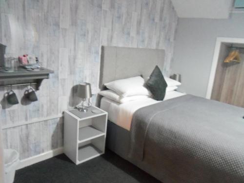 a hotel room with a bed and a night stand at The Sefton Blackpool in Blackpool