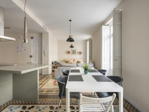 a kitchen and dining room with a white table and chairs at Macflats Ayuntamiento in Valencia