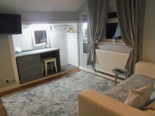 a living room with a couch and a desk at The Sefton Blackpool in Blackpool