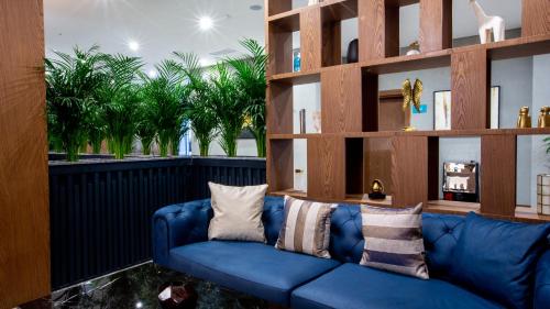 a blue couch in a living room with trees in the background at Wyndham Garden Baku in Baku