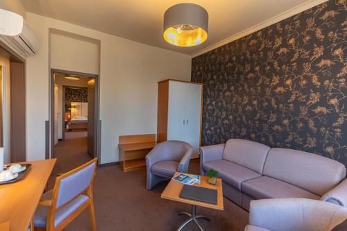 a living room with a couch and a table at City Hotel Miskolc in Miskolc