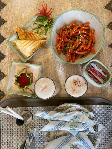 a table topped with plates of food with carrots and crackers at Anand Bagh Resort & Spa by Ananta in Sālāsar