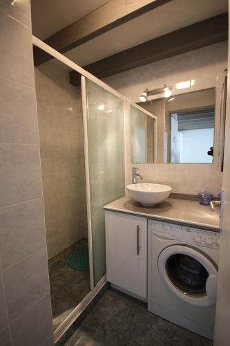 une salle de bain avec une machine à laver et un lavabo dans l'établissement Maison de vacances semi climatisée, 4 pièces 4-5 couchages, seulement 80m de la plage de PORTIRAGNES PLAGE LRCLOS10, à Portiragnes