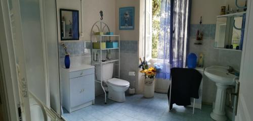 een badkamer met een toilet, een wastafel en een raam bij Casa Maria in Vico