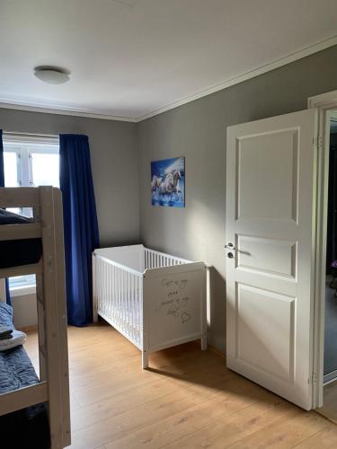 a baby room with a crib and a white door at The house of Mattis in beautiful Innvik in Innvik
