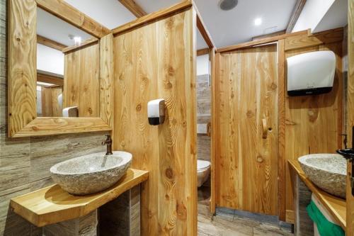 two sinks in a bathroom with wooden walls at Penzion Zora Family in Vysoke Tatry - Tatranska Lomnica.