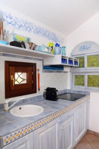 a kitchen with a sink and a counter top at villa fronte mare in Cannigione