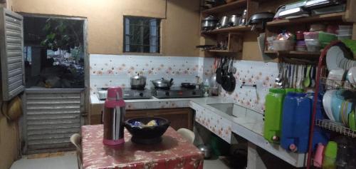 a kitchen with a counter and a table in a room at Batad Lhorens Inn and Restaurant in Banaue