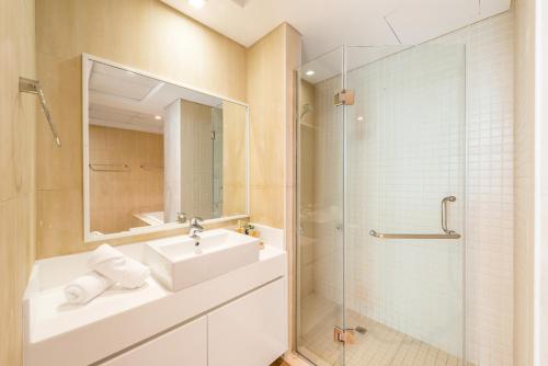 a bathroom with a sink and a glass shower at Al Bateen · Ultra Luxury JBR · Private Beach and Pool in Dubai