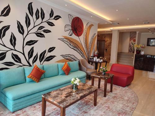 a living room with a blue couch and a flower mural at Kesuma Front One Boutique Palembang in Palembang