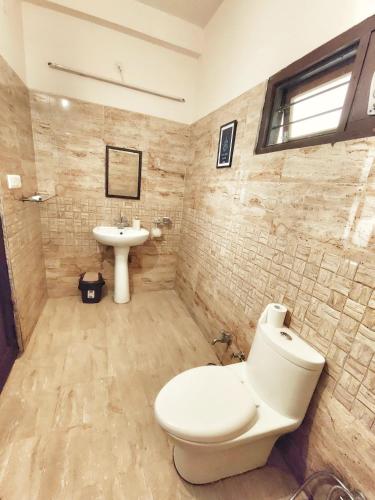 a bathroom with a toilet and a sink at Meraki - Entire 2BHK Villa With Himalayan Views in Rānīkhet