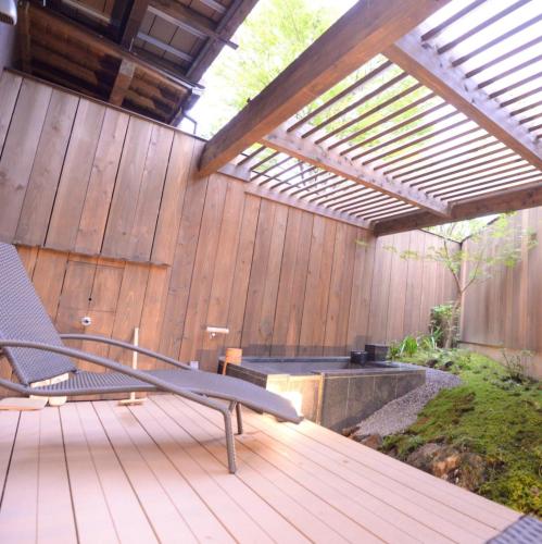 a wooden deck with a bench and a pergola at Hakone Gora Byakudan in Hakone