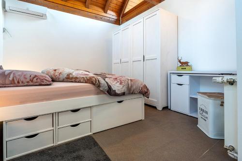 a bedroom with a bed with white cabinets and a desk at Hiesli am Goethebrunnen Ferienwohnung in Albersbach