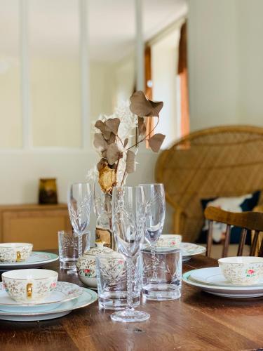 - une table en bois avec des verres et des assiettes dans l'établissement Appartements Le Tilleul de la Vallée Noble, à Westhalten