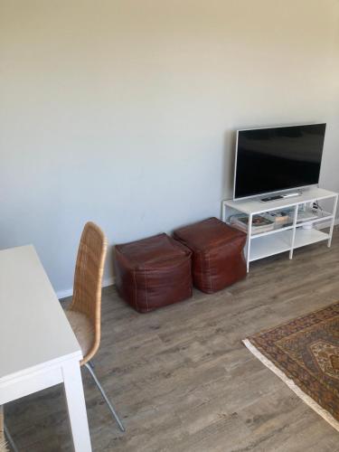 a living room with a television and a table and chairs at Stockholms home away from home in Stockholm