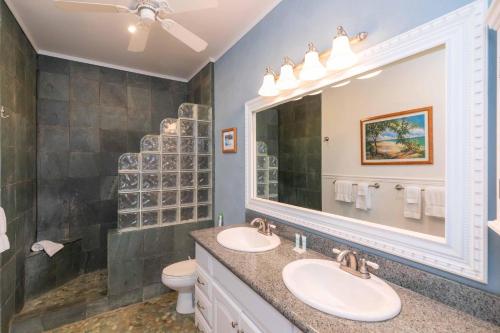 een badkamer met twee wastafels en een grote spiegel bij Kuleana Resort 207 in Kahana