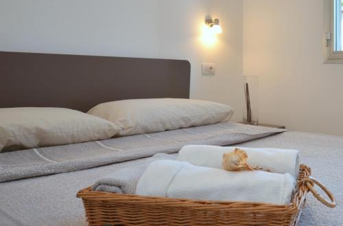 kosz z kotem siedzącym na łóżku w obiekcie Villa Gloria w Lignano Sabbiadoro