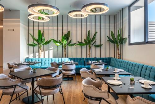 een restaurant met tafels, stoelen en planten bij Amario Suites Hotel in Aigio