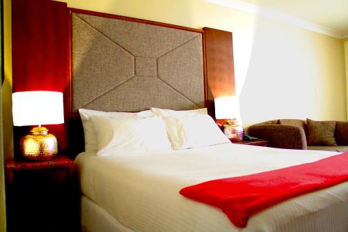 a bedroom with a large bed with a red blanket on it at Winning Post Motor Inn in Mudgee