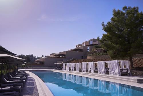 uma piscina com espreguiçadeiras e um resort em Celestial All Suites em Kefalonia