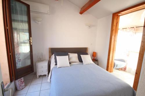 une chambre avec un lit avec des oreillers dessus dans l'établissement Maison de vacances semi climatisée, 4 pièces 4-5 couchages, seulement 80m de la plage de PORTIRAGNES PLAGE LRCLOS10, à Portiragnes