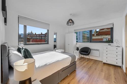 1 Schlafzimmer mit einem Bett, einem Schreibtisch und 2 Fenstern in der Unterkunft Host & Stay - Standish Street Abode in Liverpool