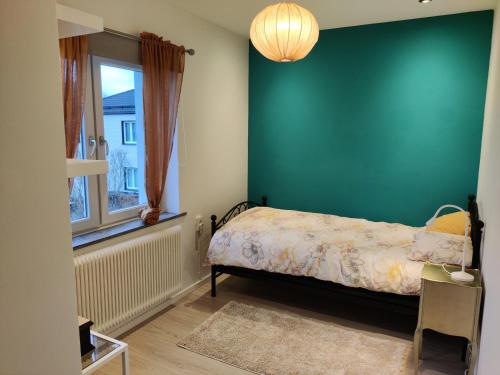 a bedroom with a bed and a green wall at Luxury Villa 130 m2 centrally in Katrineholm