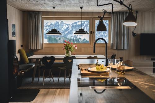 een keuken en eetkamer met een tafel en stoelen bij HALWINA Hideaway in Sibratsgfäll