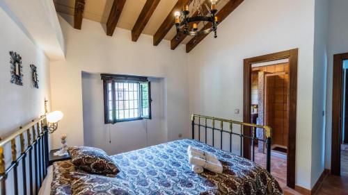 a bedroom with a bed with a blue comforter at Fuente de la Gitana Rute by Ruralidays in Rute