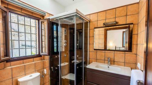 a bathroom with a sink and a shower and a mirror at Fuente de la Gitana Rute by Ruralidays in Rute