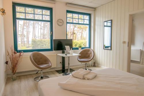 a bedroom with a bed and two chairs and a desk at Ferienanlage Zum Knirk in Lubmin