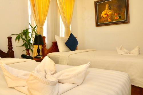 a bedroom with three beds with white sheets at The Blanc Residence in Siem Reap