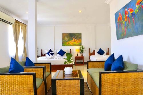 a hotel room with two beds and a living room at The Blanc Residence in Siem Reap