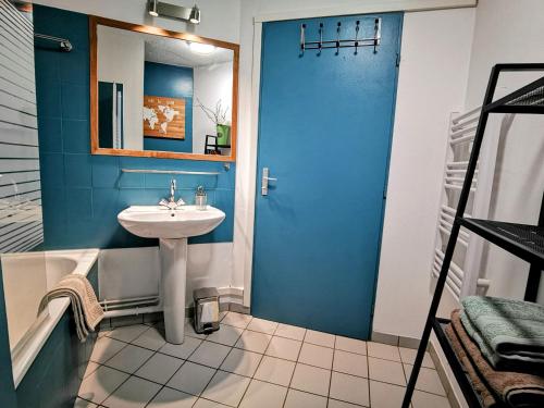 a bathroom with a sink and a blue wall at La Bulle Bleue - Parking-Terrasse-aéoport-MEET in Blagnac